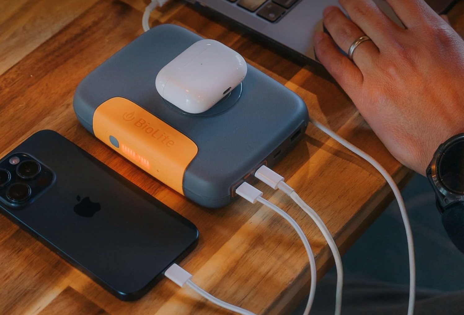 BioLite Charge in action charging a phone, air pods, and a mac laptop all at once